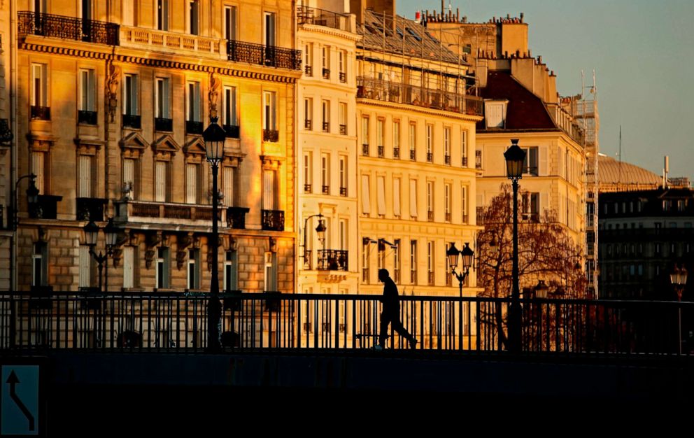 PHOTO: A runner crosses a bridge early morning in Paris on April 14, 2020, on the 29th day of a lockdown in France to stop the spread of the novel coronavirus.