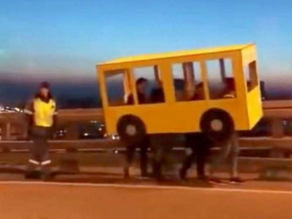 PHOTO: Une vidéo partagée largement sur les médias sociaux russes le 13 novembre 2018, montrait quatre personnes déguisées en autobus marchant sur le pont d'or à Vladivostok, en Russie.