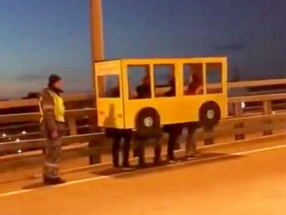 PHOTO: Une vidéo partagée largement sur les médias sociaux russes le 13 novembre 2018, montrait quatre personnes déguisées en autobus marchant sur le pont d'or à Vladivostok, en Russie.