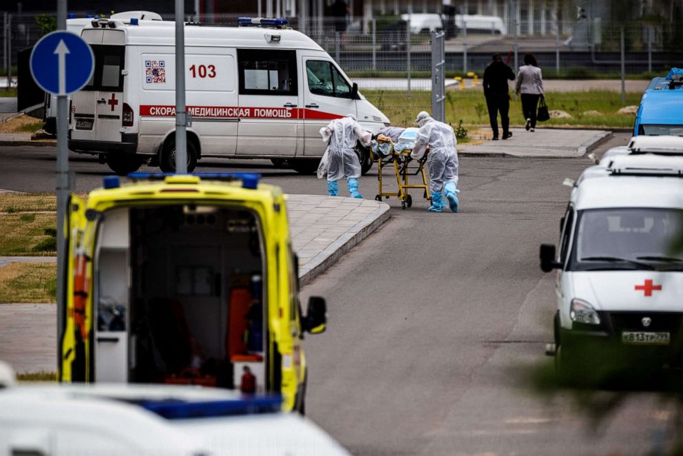 PHOTO: Medics escort a woman into a hospital where patients infected with the COVID-19 coronavirus are being treated in the settlement of Kommunarka outside Moscow on June 30, 2021.