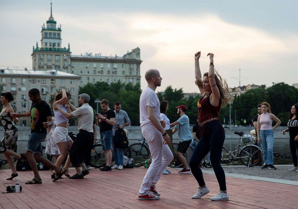 PHOTO: People dance on the first day that lockdown measures were eased at an embankment over the Moscow River in Moscow, Russia, Tuesday, June 9, 2020. 