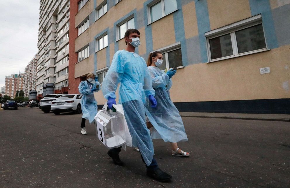 PHOTO: Members of a local election commission walk along a street carrying a portable ballot box during a nationwide vote on amendments to the Russian Constitution on the main day of voting at a polling station in Moscow, July 1, 2020.