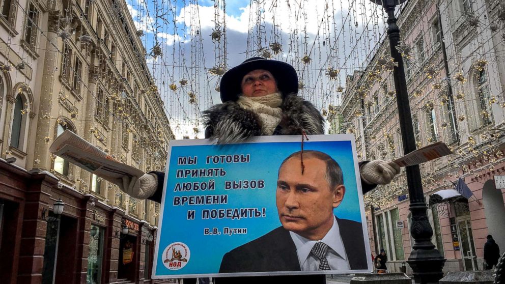 PHOTO: An activist distributes election leaflets in support of presidential candidate, President Vladimir Putin on a street in downtown Moscow, March 16, 2018.