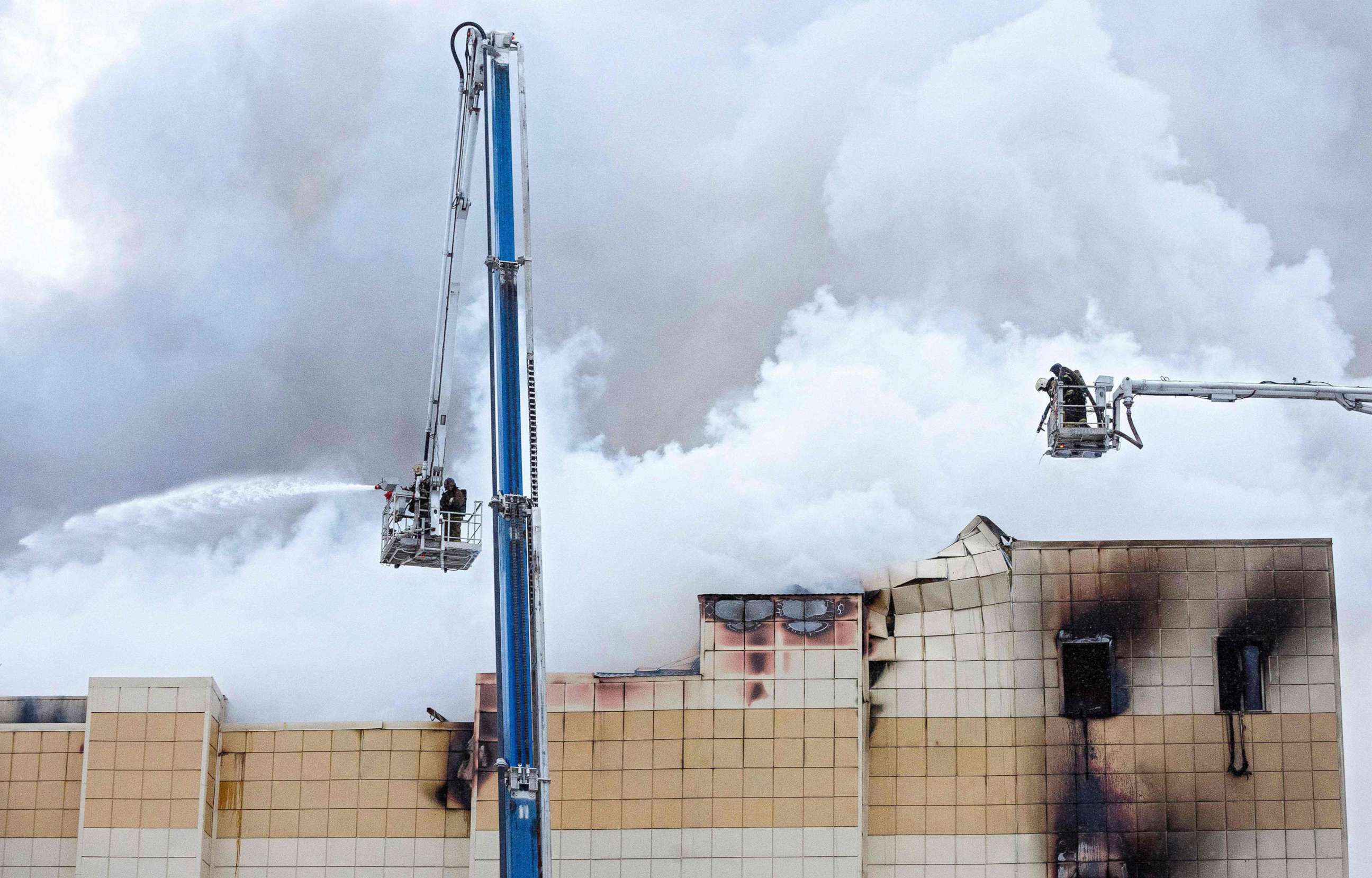PHOTO: Emergency firefighters extinguish a fire outside a burning shopping center in Kemerovo, Russia, March 25, 2018.

