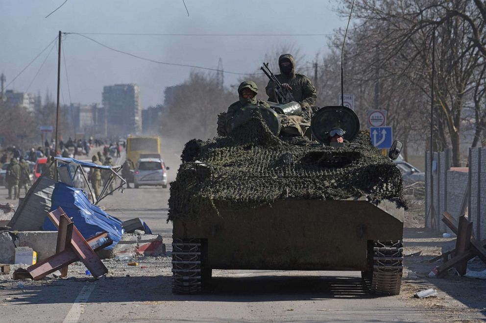 PHOTO: Service members of pro-Russian troops in uniforms without insignia drive an armoured vehicle during Ukraine-Russia conflict in the besieged southern port city of Mariupol, Ukraine, March 19, 2022.