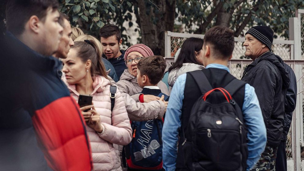 PHOTO: A woman hugs a boy surrounded by other people near the scene of a shooting at a school in Izhevsk, Russia, Sept. 26, 2022.