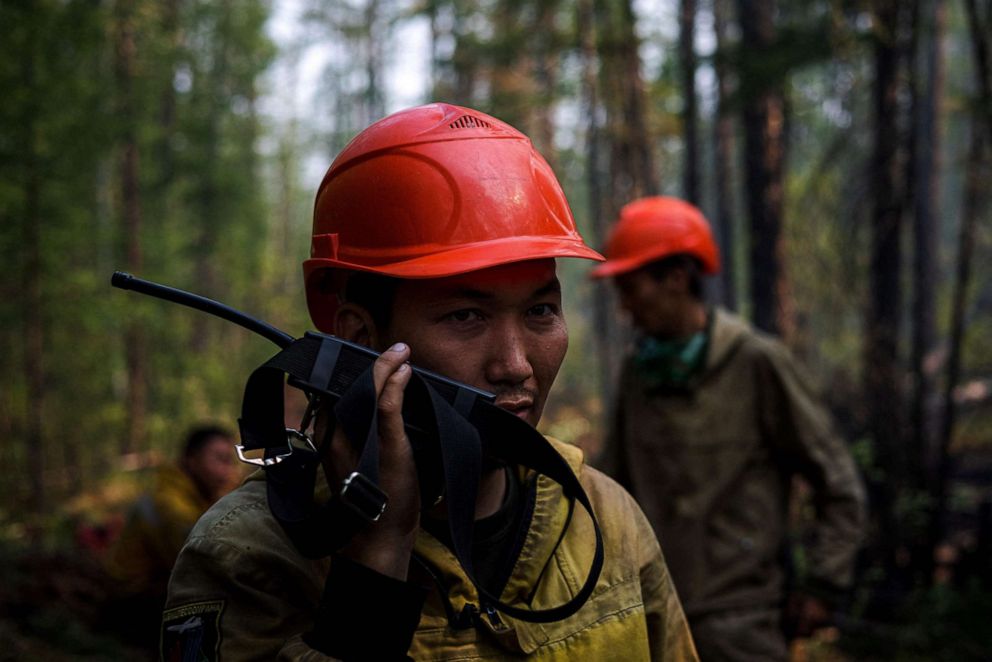 PHOTO: Members of Aerial Forest Protection Service brigade receive instructions from a pilot observer while work to extinguish a forest fire at the edge of the village of Byas-Kyuel, Russia, July 26, 2021.
