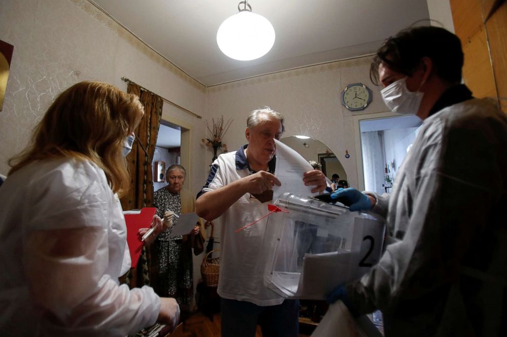 PHOTO: People cast ballots into a mobile ballot box in their apartment as members of an electoral commission wearing protective gear visit local residents on the last day of a week long nationwide vote on constitutional reforms in Moscow, July 1, 2020.