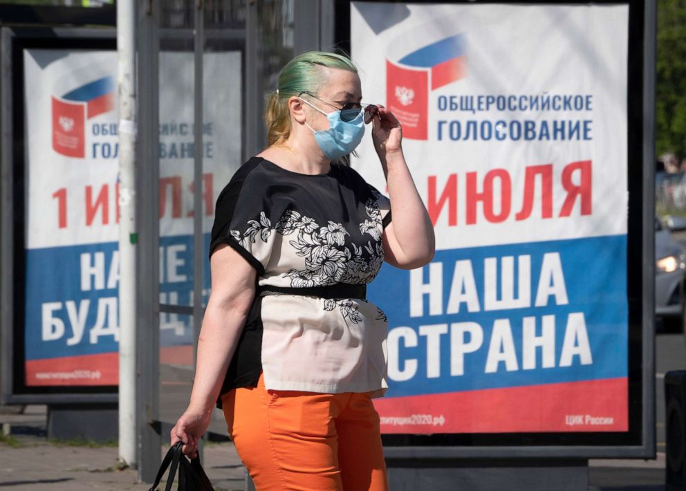 PHOTO: A woman, wearing a face mask to protect again coronavirus, walks past a billboard in St.Petersburg, Russia.