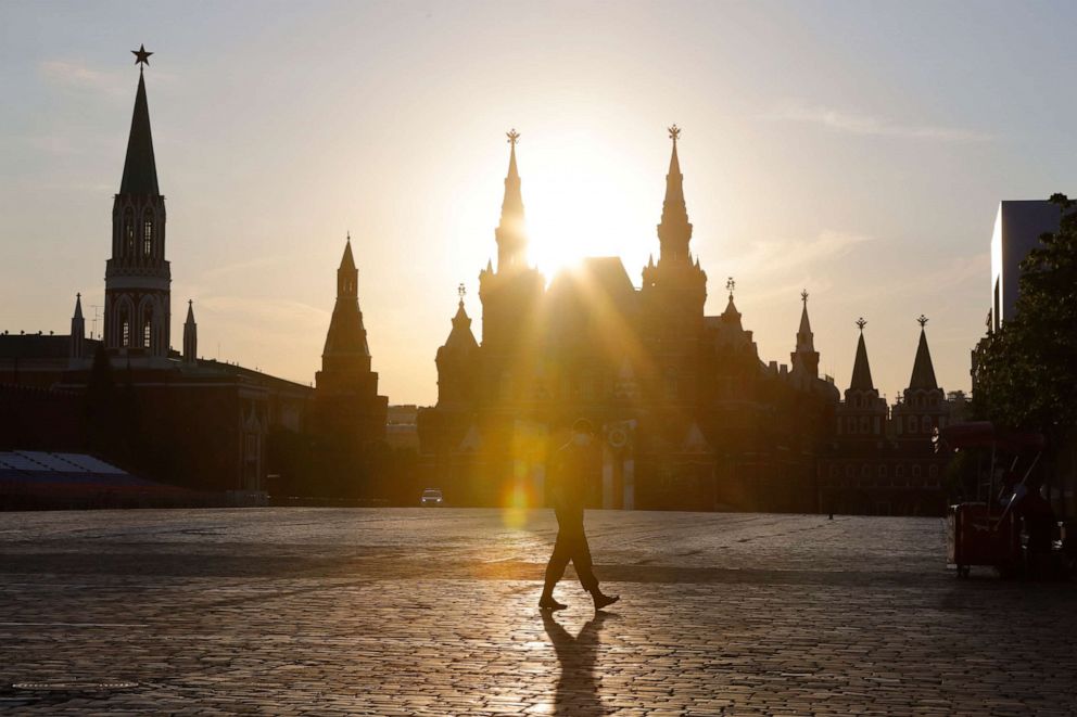 PHOTO: A Russian police officer, wearing a face mask and gloves to protect against coronavirus guards an area on Red Square before a rehearsal of the military parade in Red Square during sunset in Moscow, Russia, Sunday, June 14, 2020.