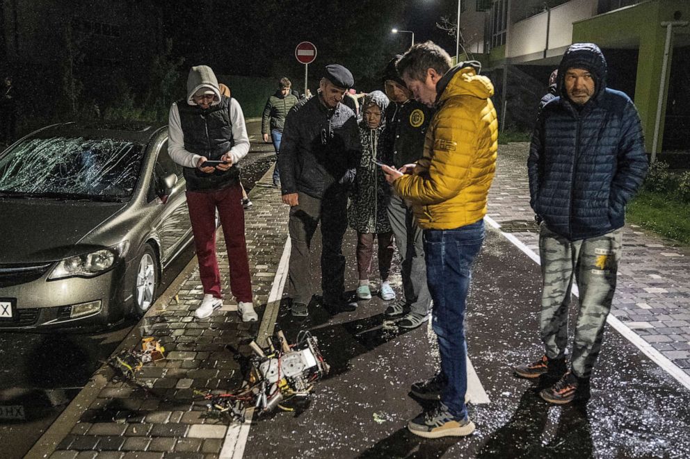 PHOTO: Local residents inspect a part of a drone, which local authorities consider to be Iranian-made, shot down during a Russian overnight strike, amid Russia's attack on Ukraine, in Kyiv, May 8, 2023.
