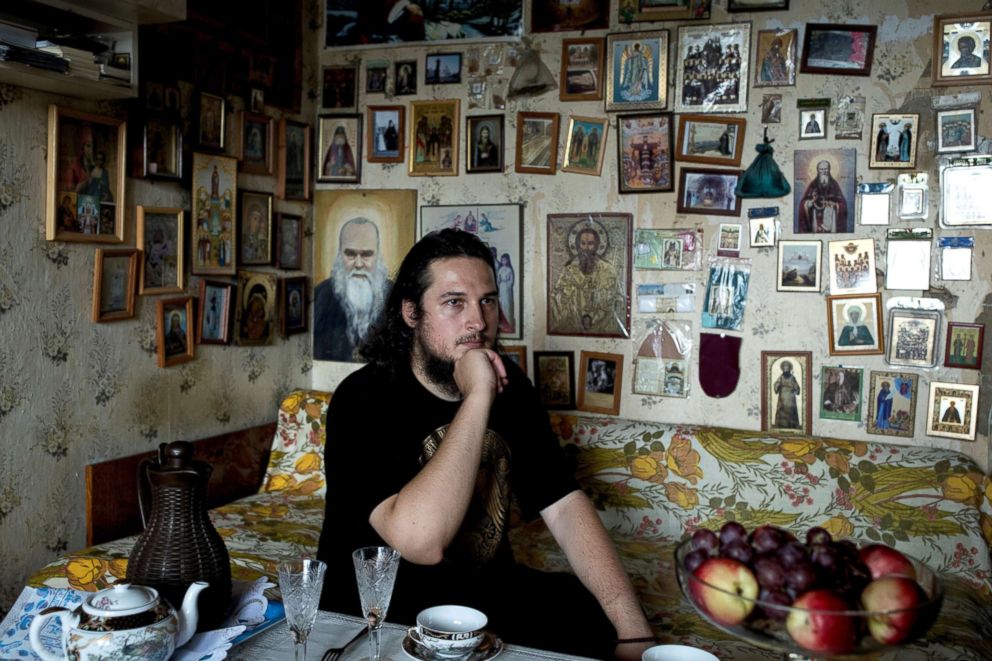 PHOTO: Pawel, a member of the Union of Orthodox Banner-Bearers, sits in his bedroom where he keeps a collection of icons from the monasteries he has visited, in Solnechnogorsk, July 19, 2018.
