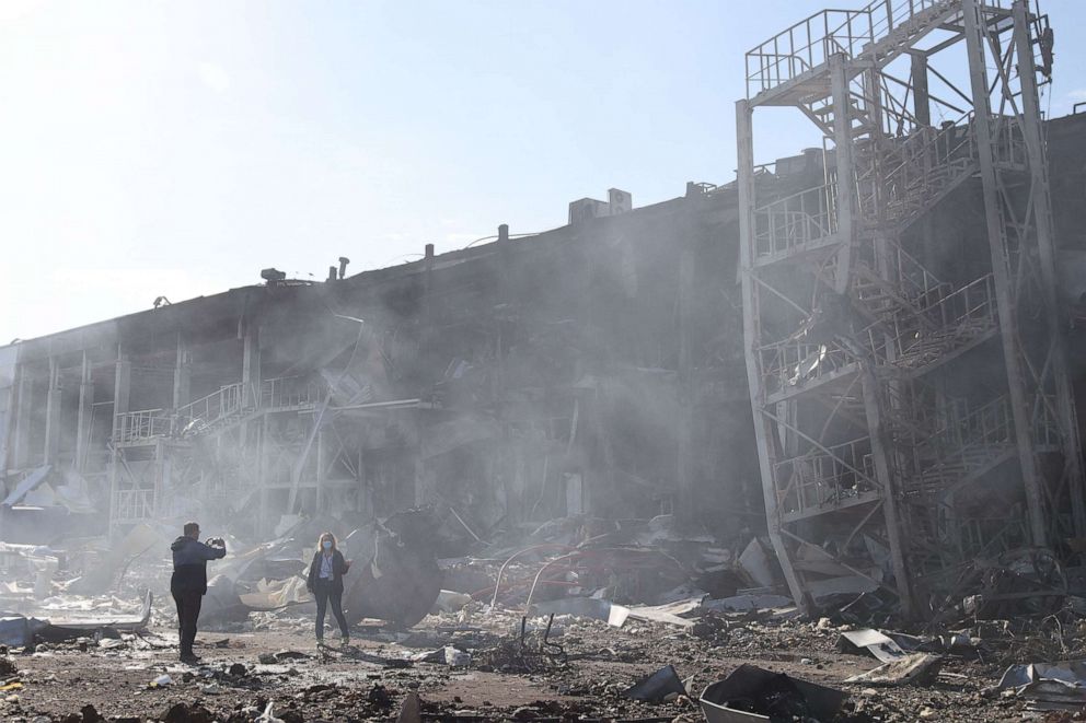 PHOTO: Onlookers take pictures in front of the shopping and entertainment center in the Ukrainian Black Sea city of Odessa on May 10, 2022, destroyed after Russian missiles strike late on May 9, 2022.