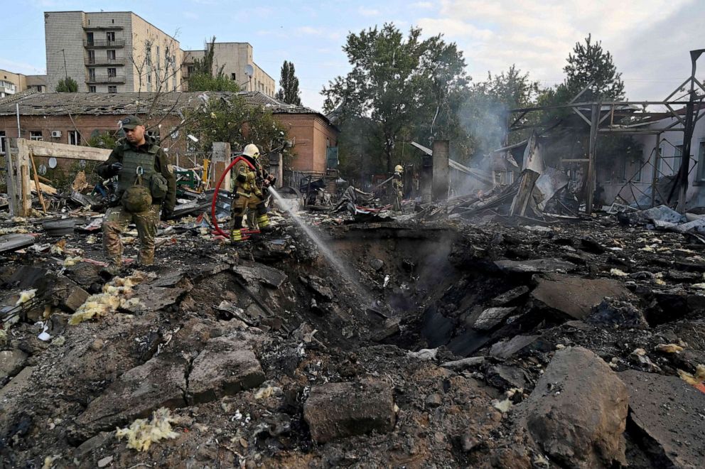 PHOTO: Firefighters extinguish flames as police experts look for fragments of missiles at a crater in an industrial area of Kyiv, Ukraine, on Sept. 21, 2023, after Russian strikes overnight.