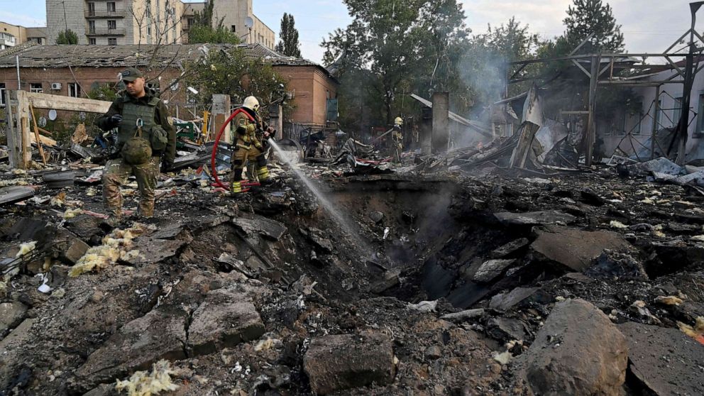 PHOTO: Firefighters extinguish flames as police experts look for fragments of missiles at a crater in an industrial area of Kyiv, Ukraine, on Sept. 21, 2023, after Russian strikes overnight.