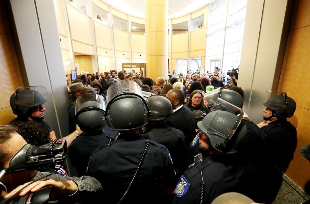 PHOTO: Sacramento police officers in riot gear block the entrance to a city council meeting at Sacramento City Hall on March 27, 2018, in Sacramento, Calif.