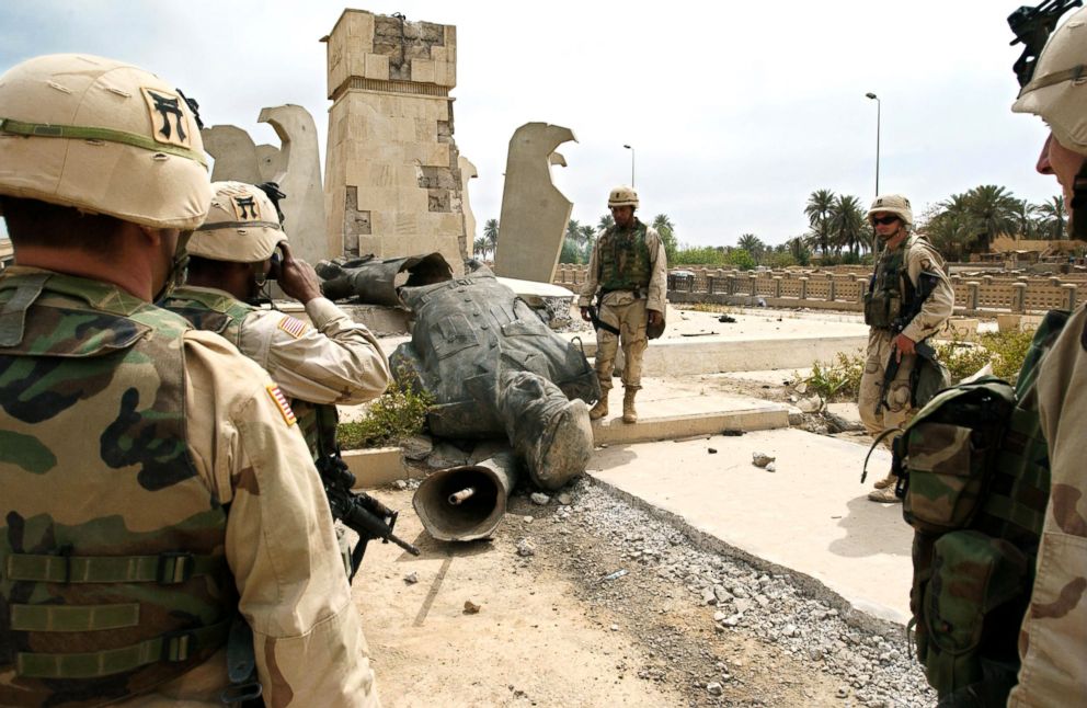 PHOTO: US soldiers shoot a picture in front of the toppled statue of Iraqi leader Saddam Hussein, April 13, 2003, in Baghdad.