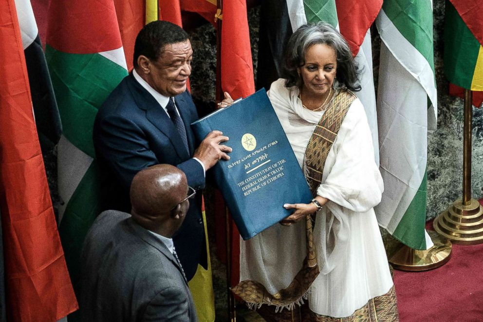 PHOTO: Ethiopia's first female President Sahle-Work Zewde, right, recieves a book of the Constitution from former President Mulatu Teshomea at the Parliament in Addis Ababa, Oct. 25, 2018.