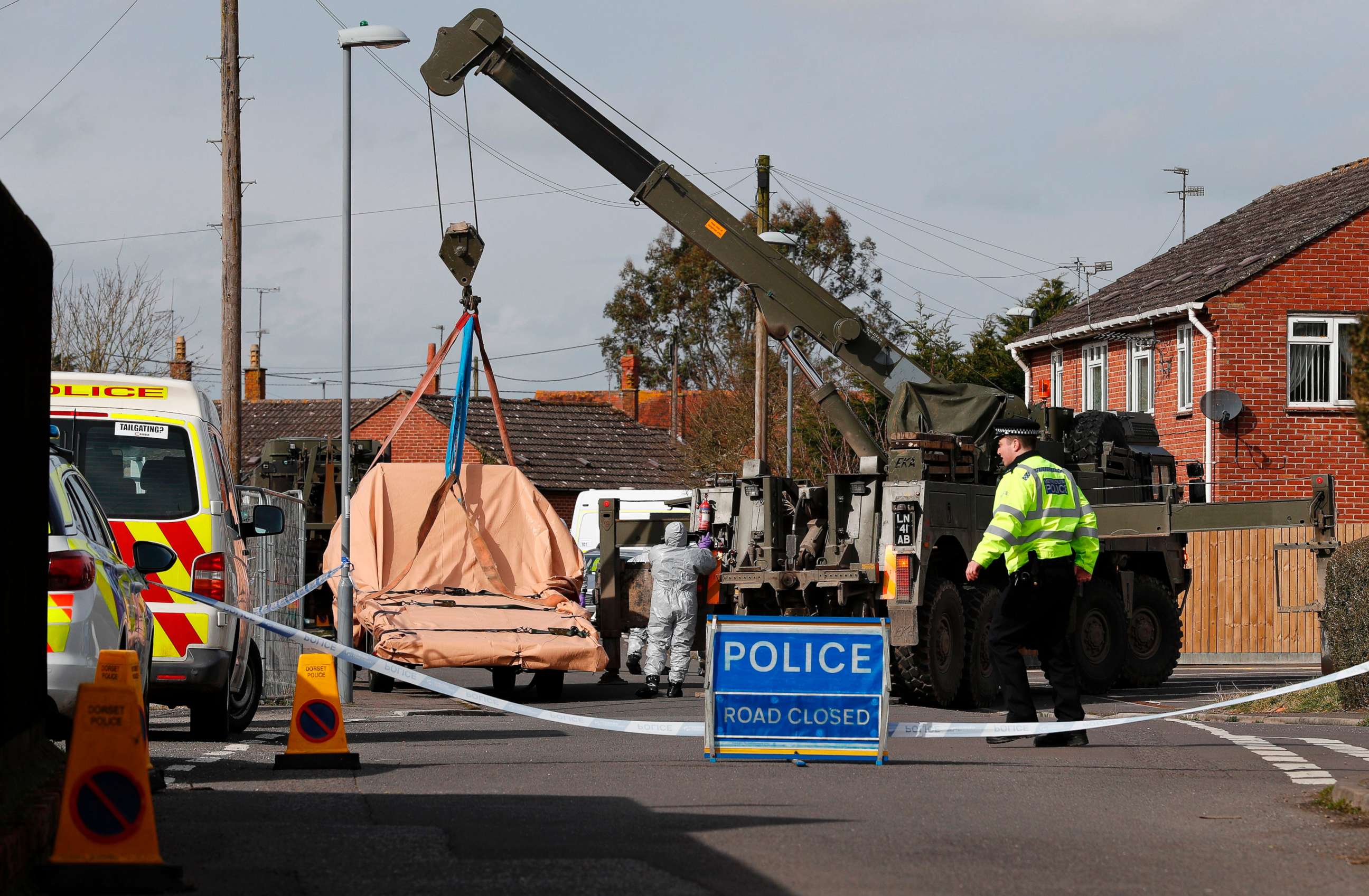 PHOTO: British Military personnel wearing protective coveralls work to remove a vehicle connected to the March 4 nerve agent attack in Salisbury, from a residential street in Gillingham, southeast England on March 14, 2018.
