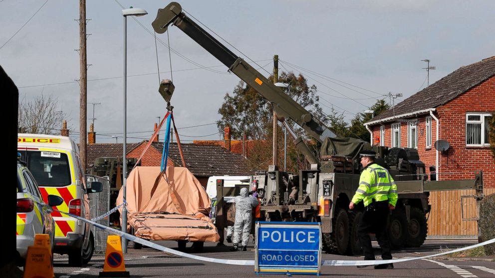 PHOTO: British Military personnel wearing protective coveralls work to remove a vehicle connected to the March 4 nerve agent attack in Salisbury, from a residential street in Gillingham, southeast England on March 14, 2018.
