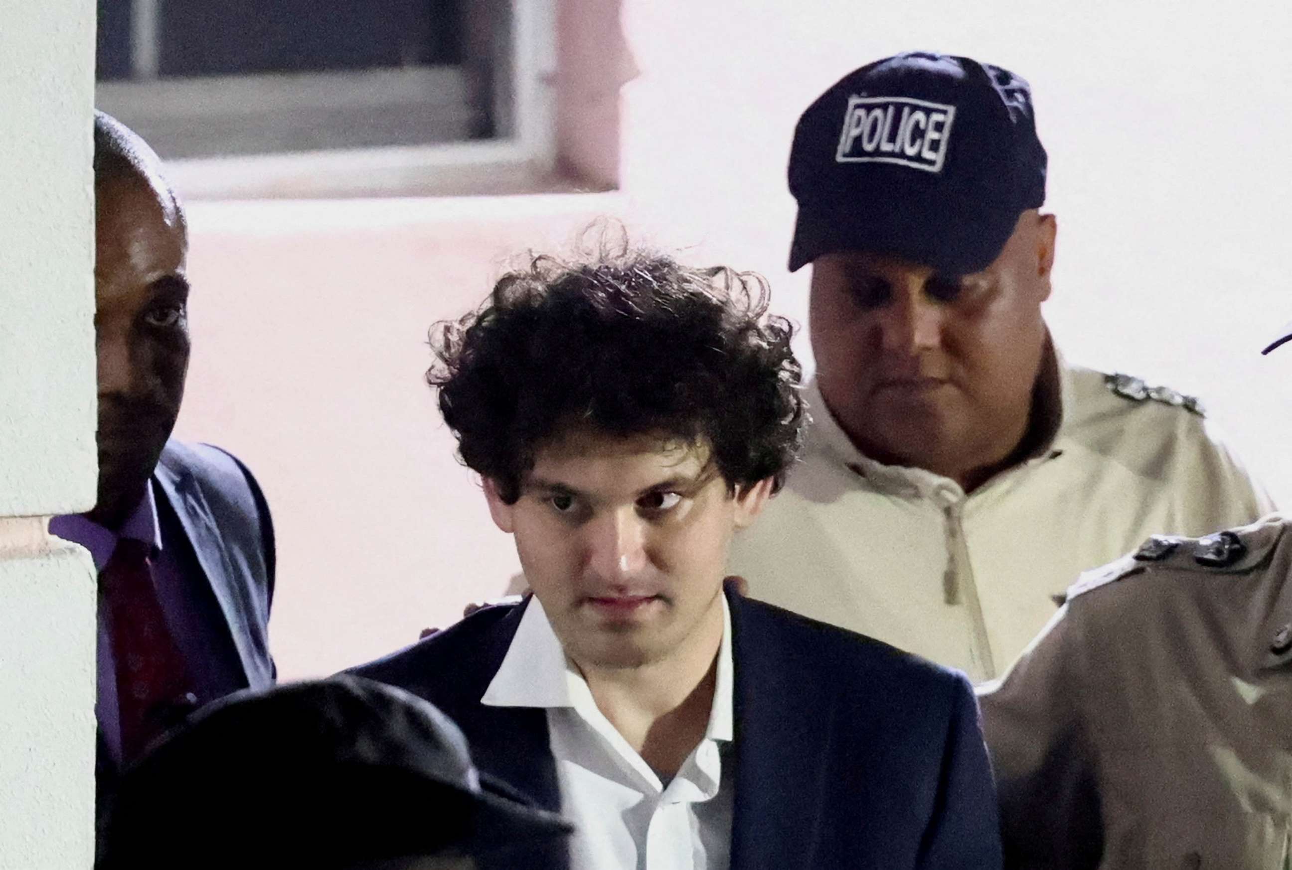 PHOTO: FILE - Sam Bankman-Fried, who founded and led FTX until a liquidity crunch forced the cryptocurrency exchange to declare bankruptcy, is escorted out of the Magistrate Court building after his arrest in Nassau, Bahamas, Dec. 13, 2022.