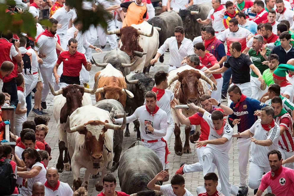 PHOTO: In this file photo taken on July 9, 2019, participants run next to Jose Escolar Gil fighting bulls on the third bull run of the San Fermin festival in Pamplona, northern Spain.