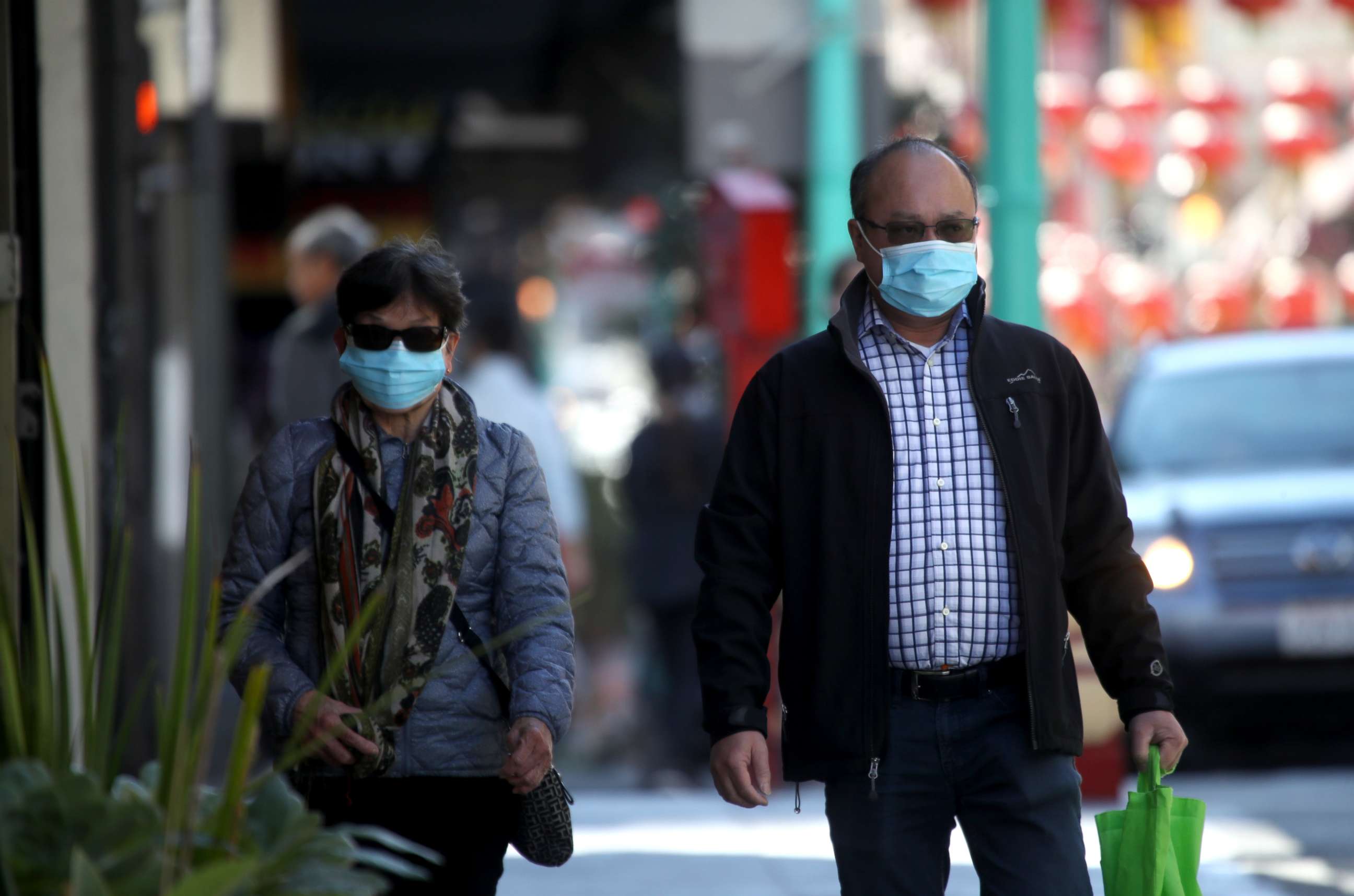 PHOTO: People wear surgical masks as they walk along Chinatown's Grant Avenue in San Francisco, California, on Feb. 26, 2020.