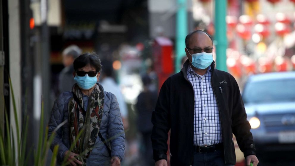 PHOTO: People wear surgical masks as they walk along Chinatown's Grant Avenue in San Francisco, California, on Feb. 26, 2020.