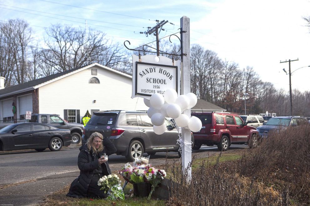 PHOTO: Local residents place flowers near the Sandy Hook Elementary School, Dec. 15, 2012, in Sandy Hook, Conn., for the 28 children and faculty shot and killed one day earlier. 