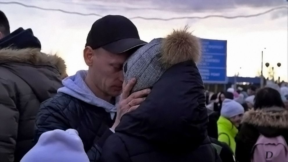 PHOTO: Ukrainian husband and wife Sasha and Svetlana Olekciirak say goodbye as they separate at the Polish border.