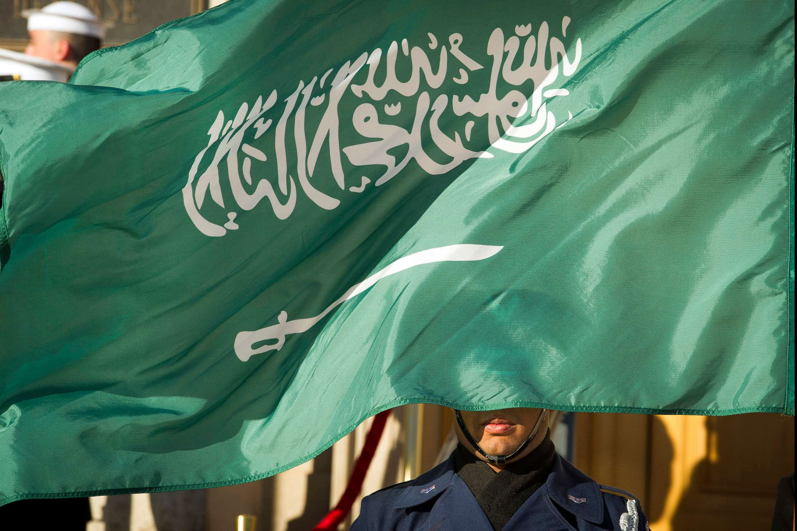 PHOTO:In this March 22, 2018 file photo, an Honor Guard member is covered by the flag of Saudi Arabia.