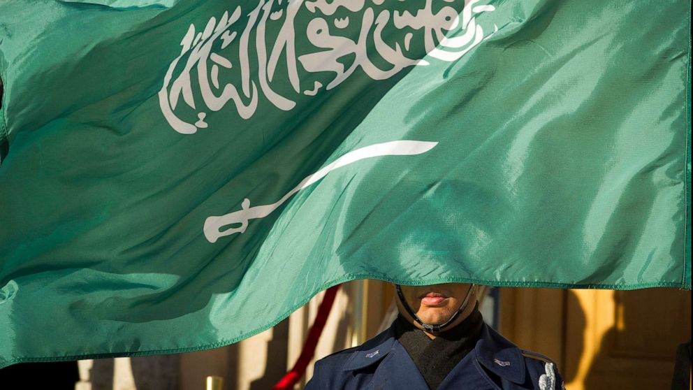 PHOTO:In this March 22, 2018 file photo, an Honor Guard member is covered by the flag of Saudi Arabia.
