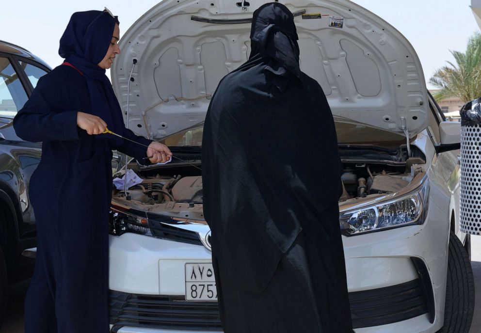 PHOTO: A Saudi trainee shows a female driver how to check a car's engine oil level at the Saudi Driving School (SDS), in Riyadh, Saudi Arabia on June 24, 2019.