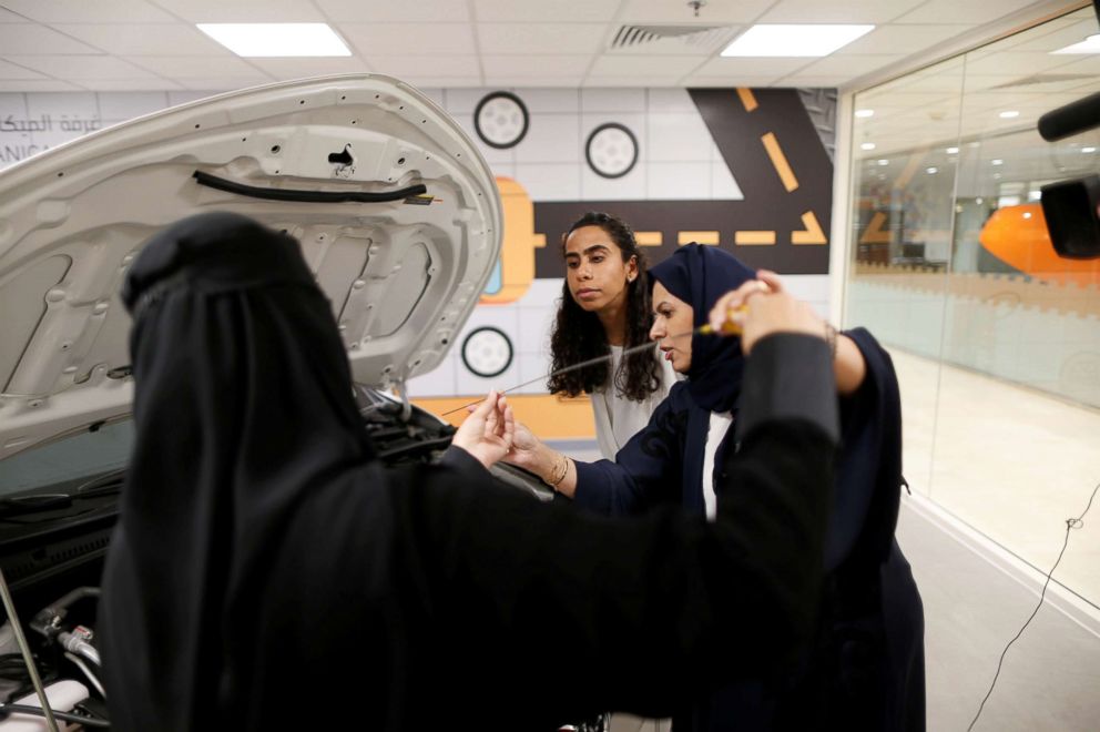 PHOTO: Trainees Maria al-Faraj, center, and Amira Abdelgader check oil level in the engine with their driving instructor, right, during a lesson at Saudi Aramco Driving Center in Dhahran, Saudi Arabia, June 6, 2018.