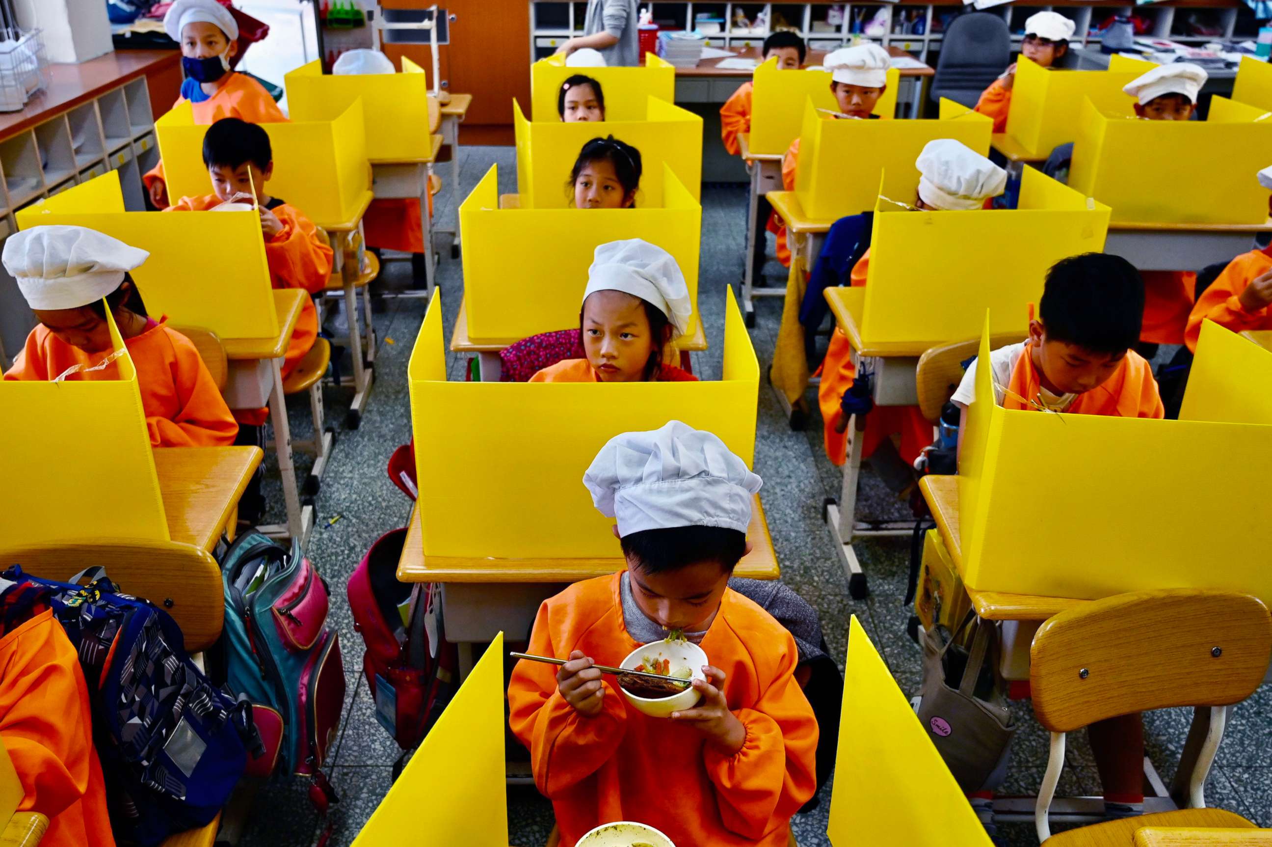 PHOTO:Students eat their lunch on desks with plastic partitions as a preventive measure to curb the spread of COVID-19 at Dajia Elementary School, in Taipei, on April 29, 2020.