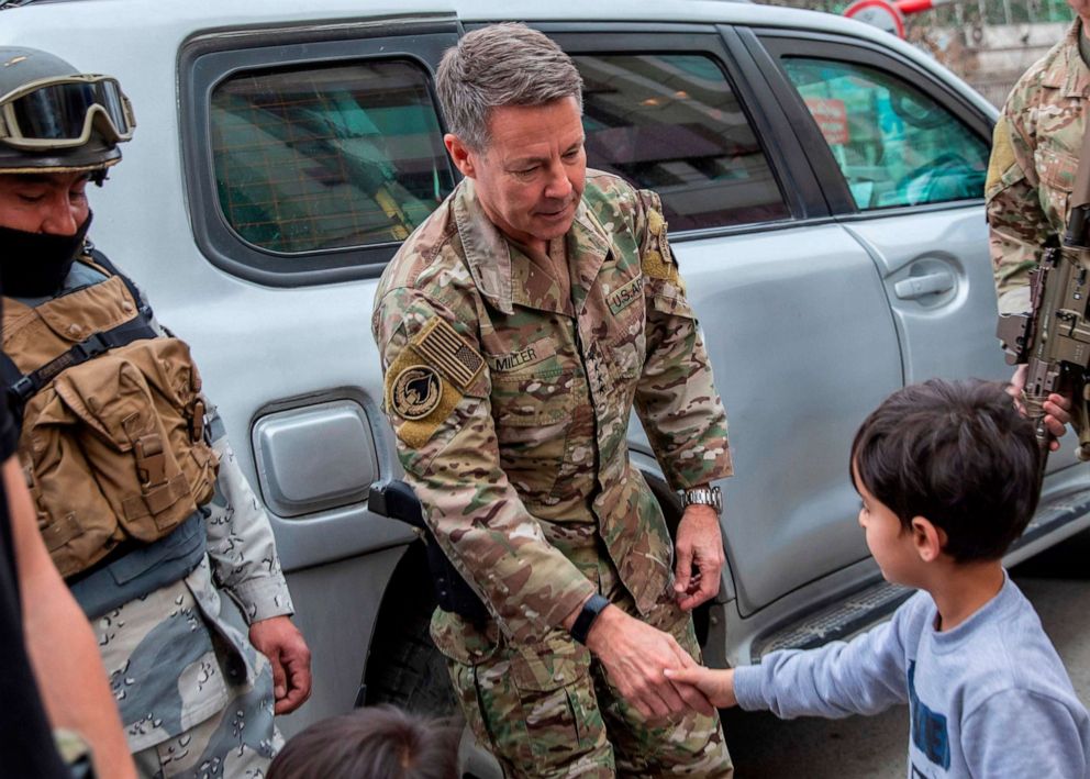 PHOTO: In this handout photo taken and released by Afghanistan's Ministry of Defence office on Feb. 26, 2020, Commander of U.S. and NATO forces in Afghanistan Gen. Austin Scott Miller shakes hands with a young boy, in the city of Kabul.