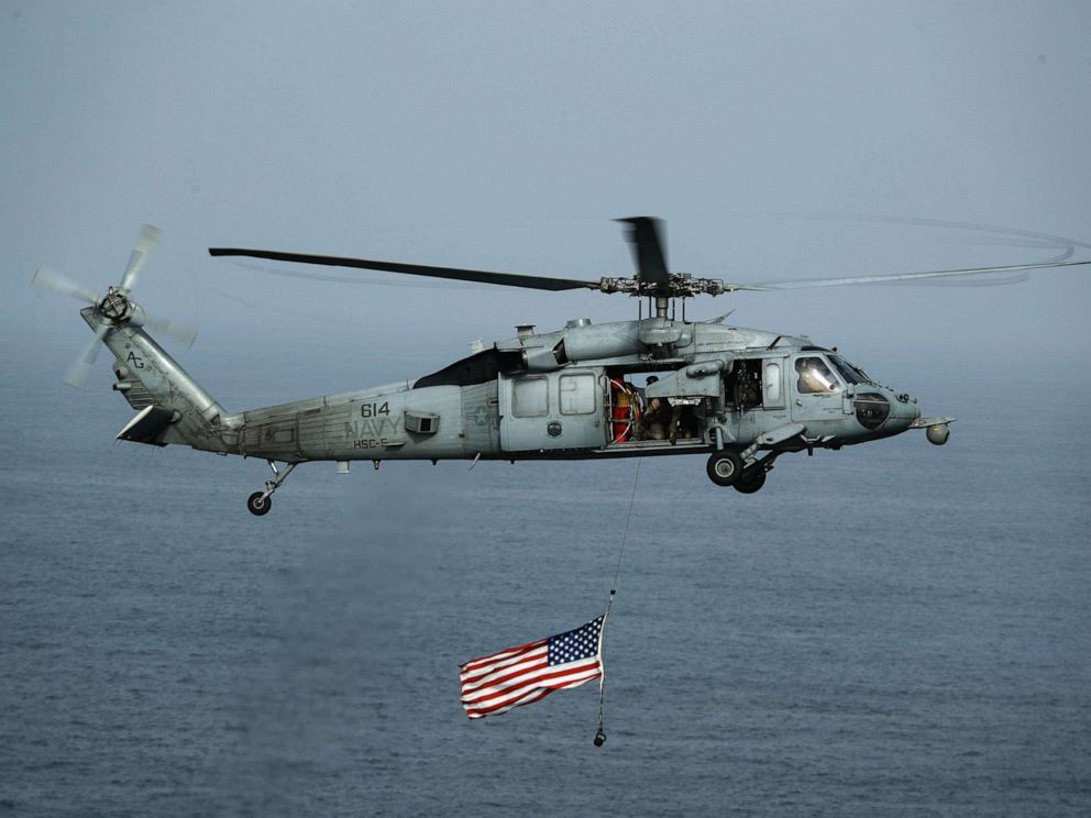 PHOTO: An MH-60S Sea Hawk helicopter flies over the Nimitz-class aircraft carrier USS Abraham Lincoln, July 4, 2019.