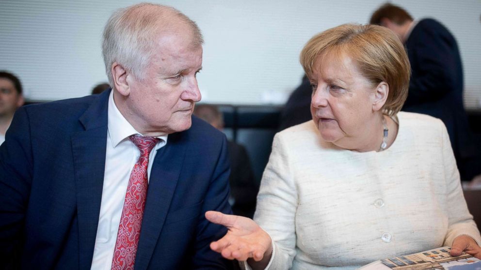 German Chancellor and leader of the Christian Democratic Union (CDU) party Angela Merkel talks with German Interior Minister Horst Seehofer (CSU) prior a parliamentary group meeting CDU/CSU at the Reichstag parliament building, June 12, 2018, in Berlin.