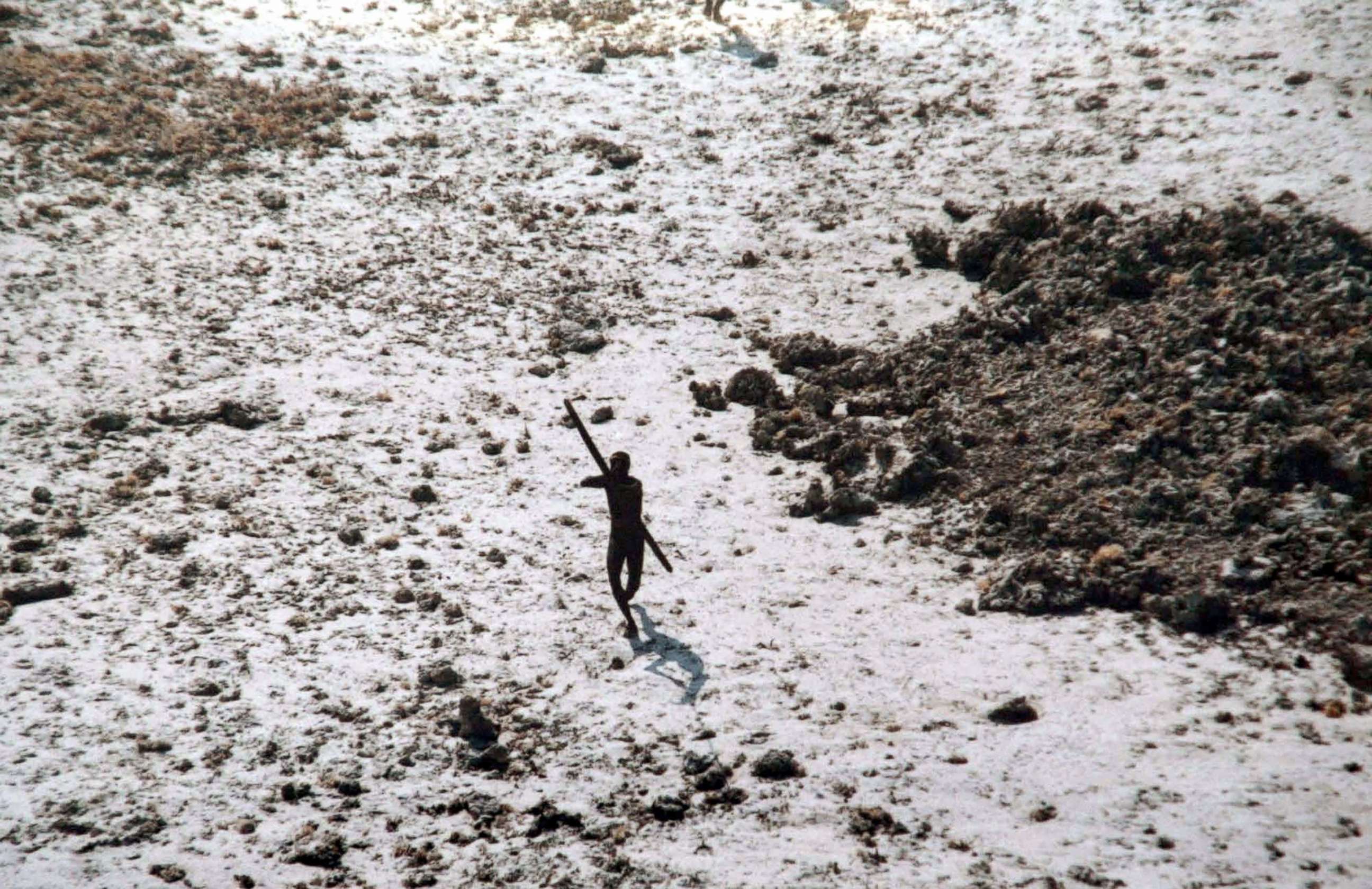 PHOTO: A man with the Sentinelese tribe aims his bow and arrow at an Indian Coast Guard helicopter as it flies over North Sentinel Island in the Andaman Islands, Dec. 28, 2004.