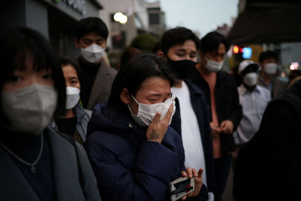 PHOTO: People react near the scene of a crowd crush that happened during Halloween festivities, in Seoul, South Korea, on October 31, 2022. 