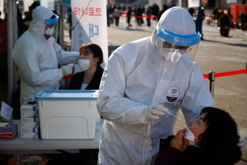 PHOTO: People undergo COVID-19 tests at a coronavirus testing site which is temporarily set up in front of a railway station in Seoul, Dec. 21, 2020. 
