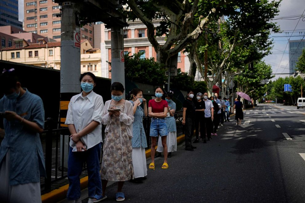 PHOTO: People line up for nucleic acid tests on a street, amid new lockdown measures in parts of the city to curb the coronavirus outbreak in Shanghai, China, June 11, 2022.