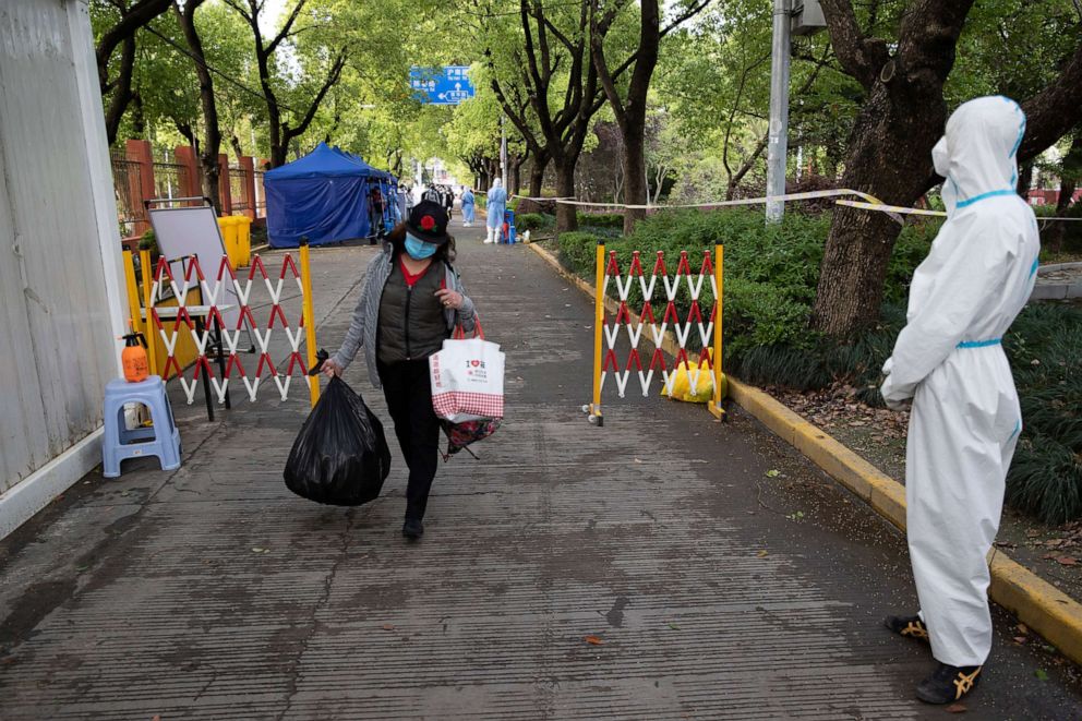 PHOTO: In this photo released by Xinhua News Agency, a villager carrying baggage returns home after being quarantined due to local COVID cases found in Lianqin Village of Beicai Town in Pudong New Area, Shanghai, China, April 26, 2022.