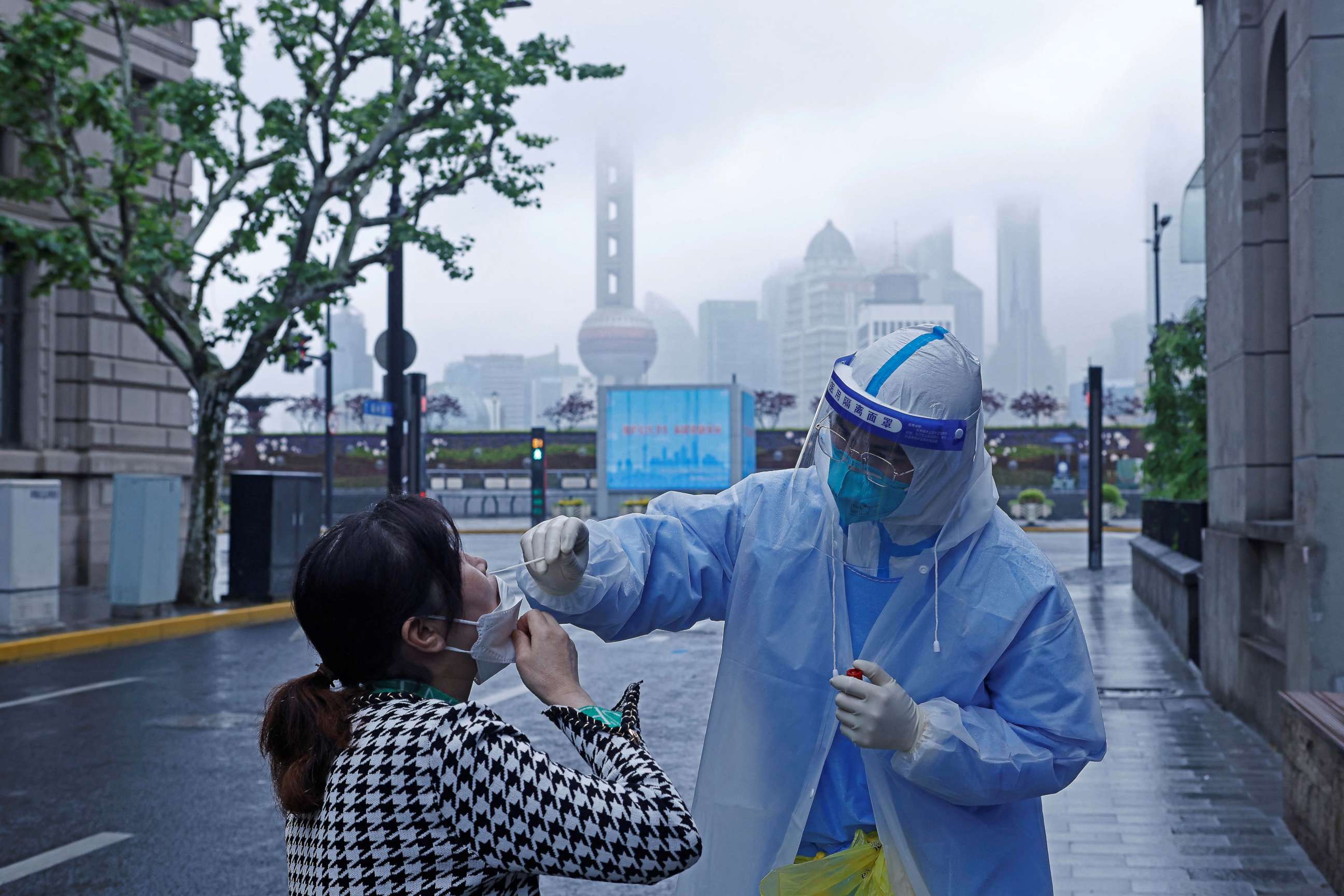 PHOTO: A medical worker in protective gear collects a swab sample from a resident for nucleic acid testing, amid the COVID-19 outbreak, in Shanghai, China, April 26, 2022.