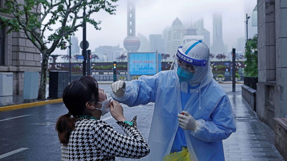 PHOTO: A medical worker in protective gear collects a swab sample from a resident for nucleic acid testing, amid the COVID-19 outbreak, in Shanghai, China, April 26, 2022.