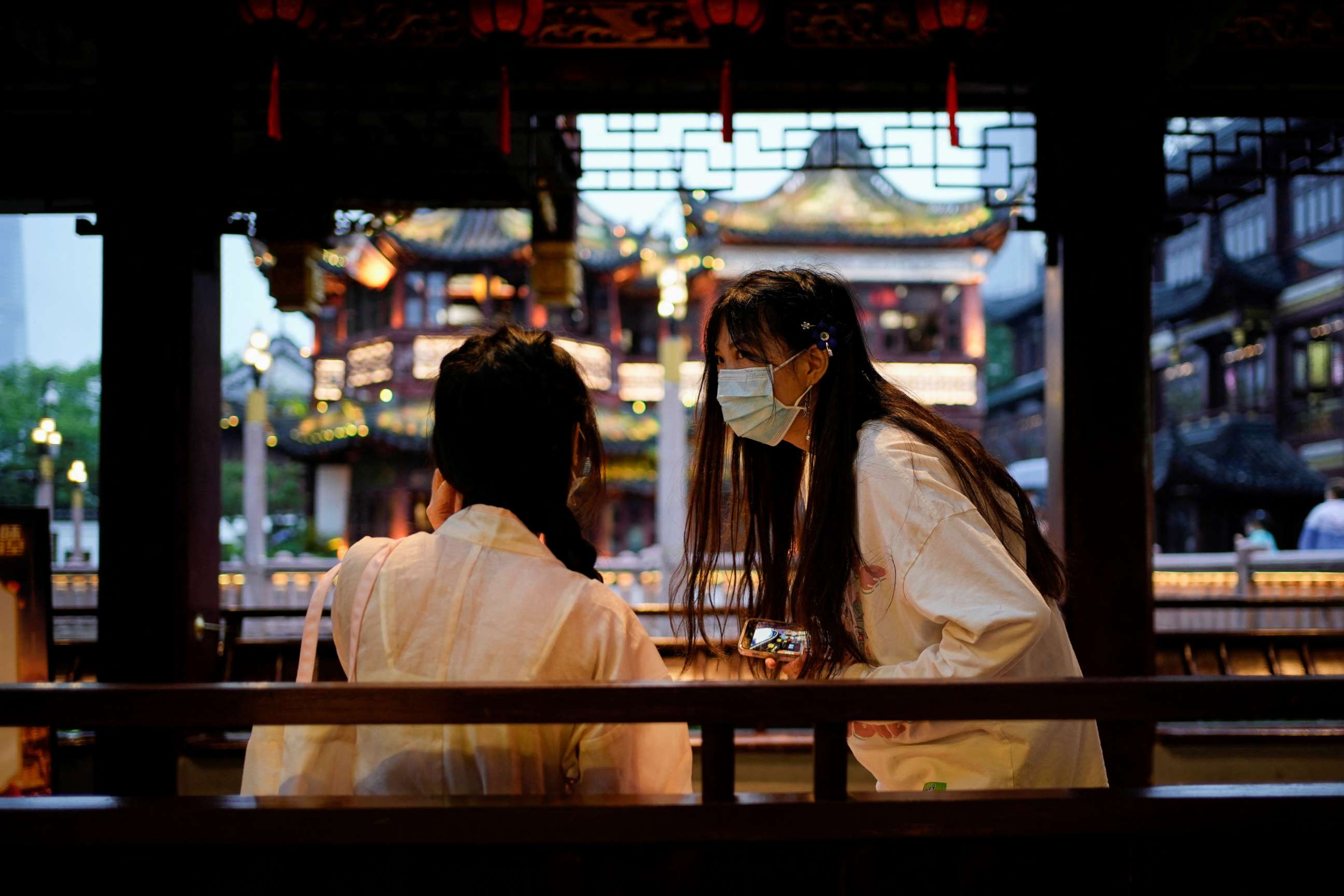 PHOTO: People wearing protective face masks chat in Yu Garden, amid new lockdown measures in parts of the city to curb the coronavirus disease outbreak in Shanghai, China. June 10, 2022.