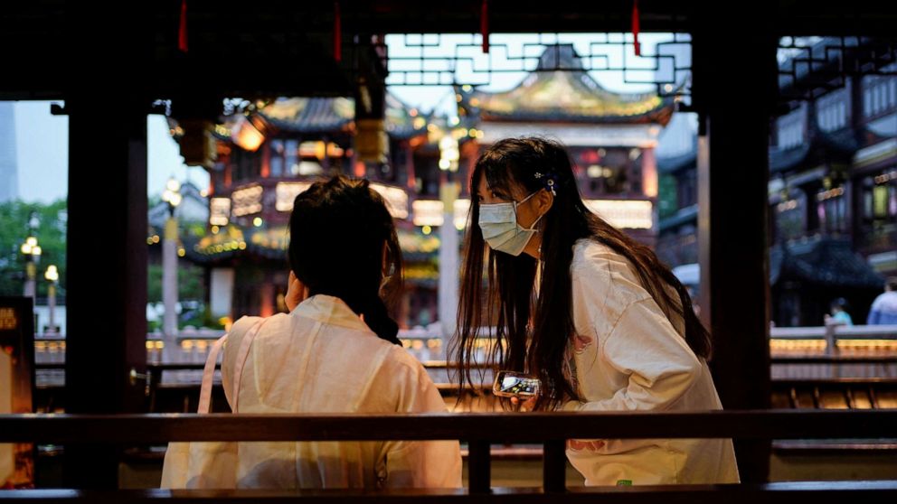 PHOTO: People wearing protective face masks chat in Yu Garden, amid new lockdown measures in parts of the city to curb the coronavirus disease outbreak in Shanghai, China. June 10, 2022.