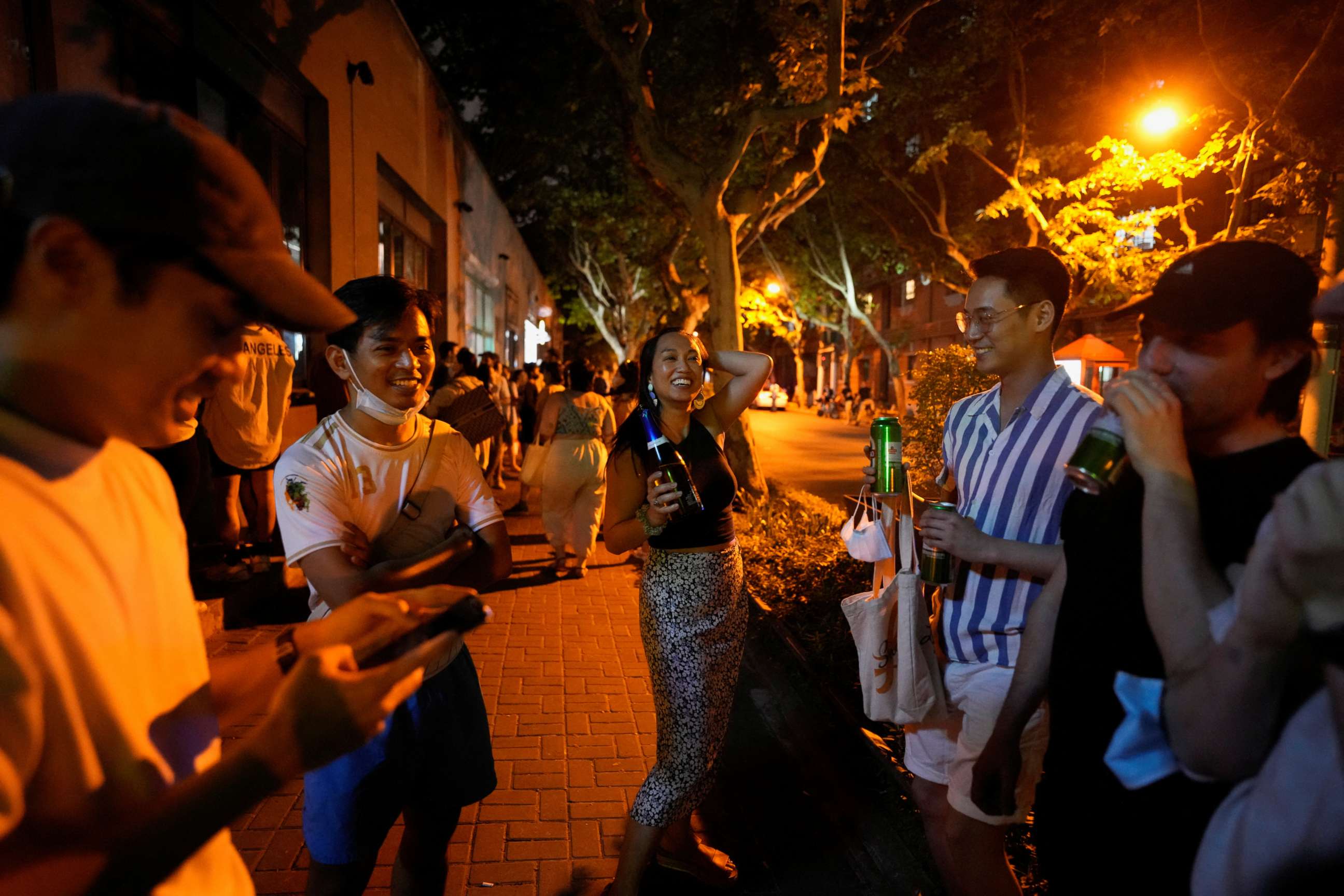 PHOTO: People drink on a street, as the city prepares to end the lockdown placed to curb the coronavirus disease outbreak in Shanghai, China, May 31, 2022.