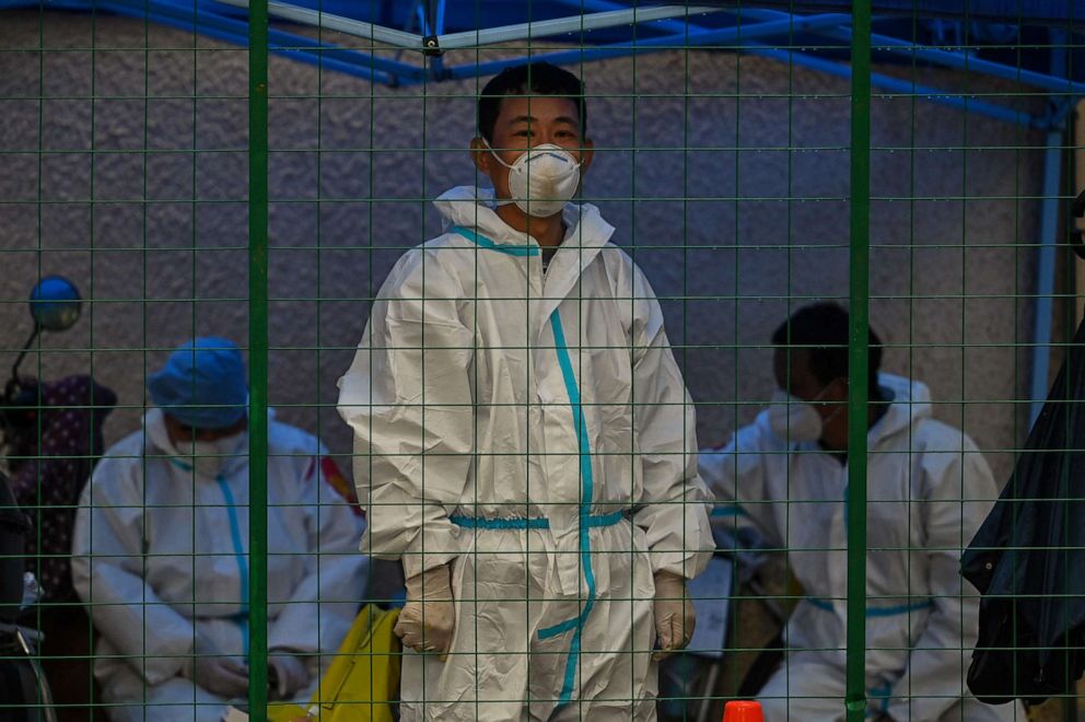 PHOTO: A worker wearing personal protective equipment stands behind a fence in a residential area under COVID-19 lockdown in the Huangpu district of Shanghai, China, on June 13, 2022.