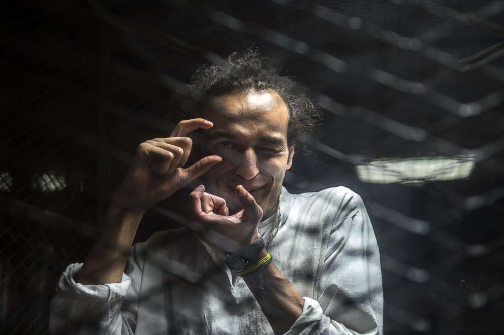 PHOTO: Egyptian photojournalis Mahmoud Abu Zeid, known as Shawkan, mimics taking a photograph from inside a soundproof glass dock during his trial in Cairo, Aug. 9, 2016.